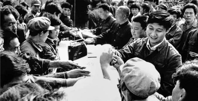1984年10月，习近平在正定县城街头发放民意调查表。（图源：《让群众过上好日子——习近平正定足迹》）